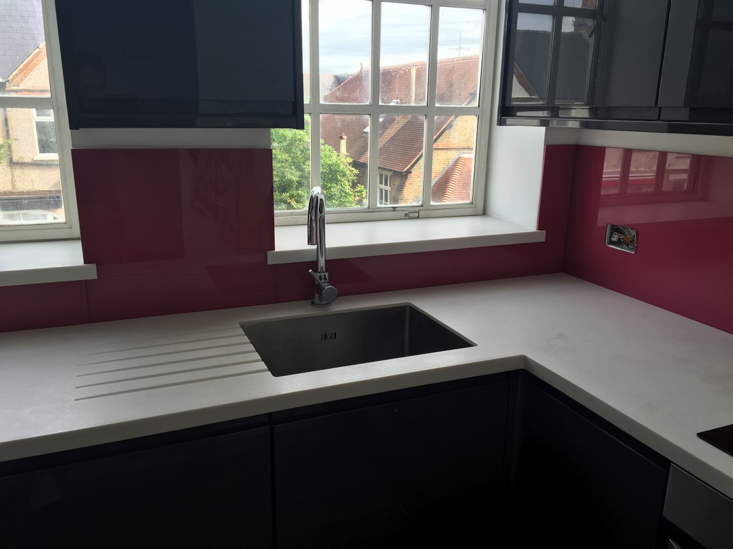 Deep plum coloured glass splashback in modern  Bromley by Bow kitchen